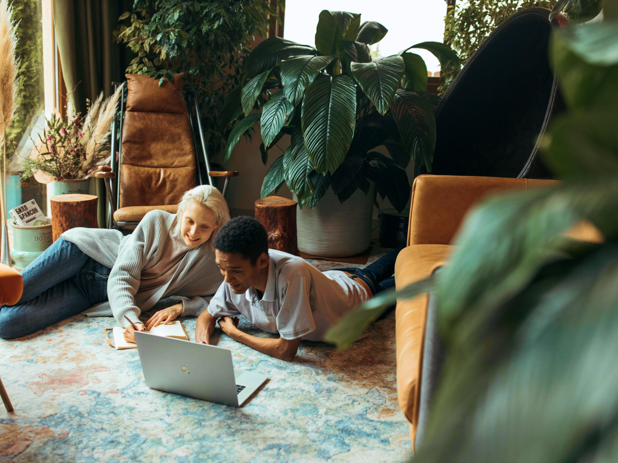 Two people sharing a laptop on the floor